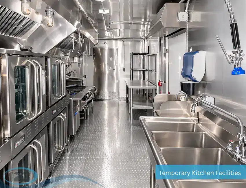 Interior of a commercial mobile kitchen featuring stainless steel workstations, sinks, cooking equipment, and ventilation.