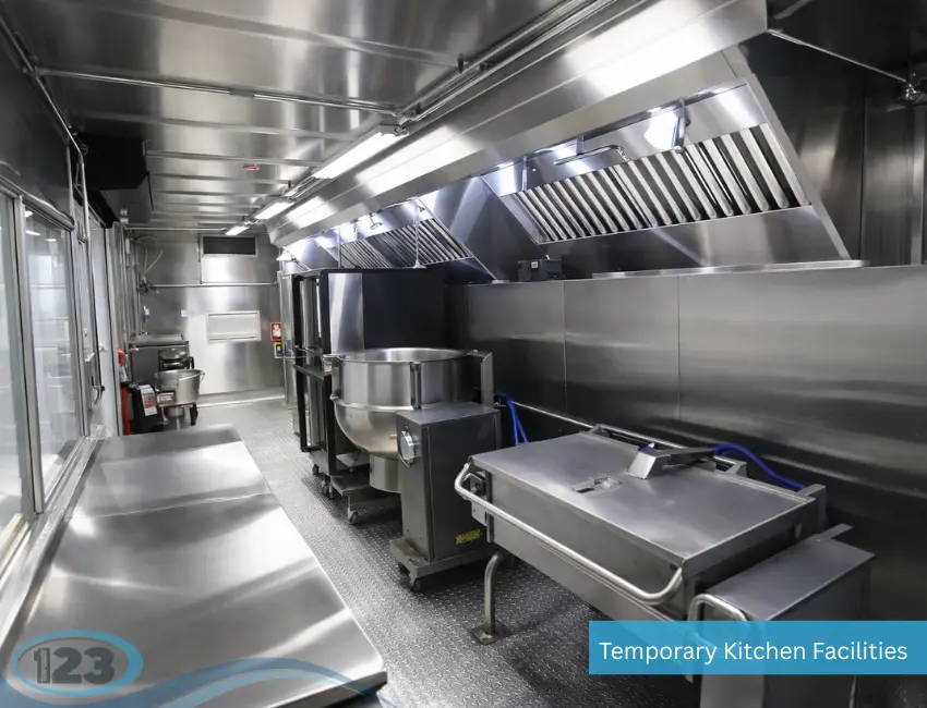 Interior of a commercial mobile kitchen featuring stainless steel prep stations, sinks, and industrial cooking equipment.