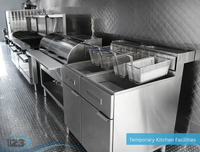 Stainless steel commercial deep fryer station inside a mobile kitchen trailer for high-volume food preparation.